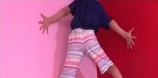 niña escala una pared con sus manos