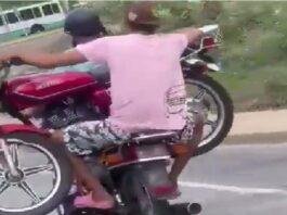 Dos motorizados cargan moto La Guaira